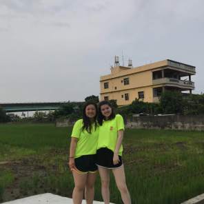 Co-teachers standing in the rice fields surrounding our school